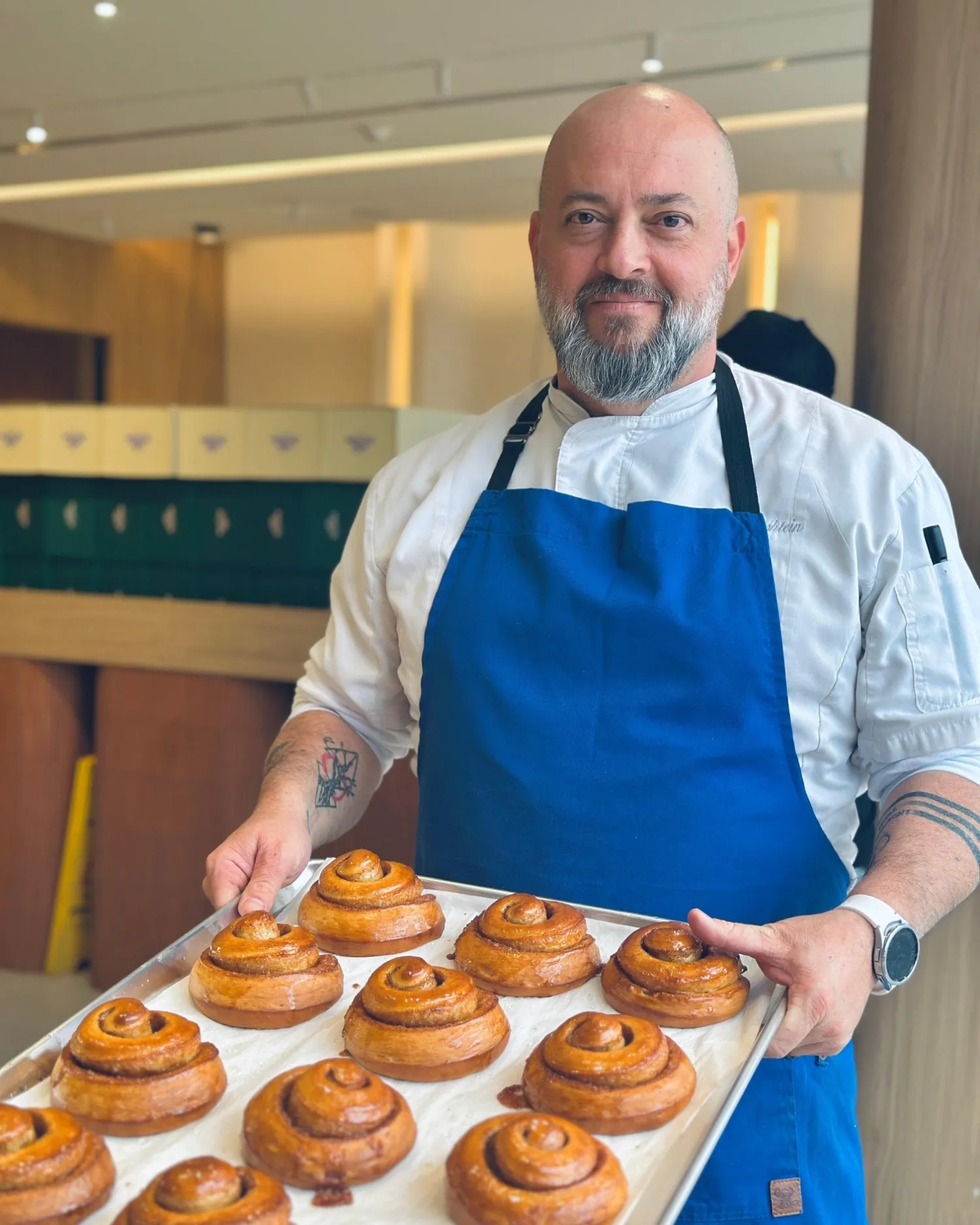 Oren Zilbershtein holding a tray of fresh cinnamon buns